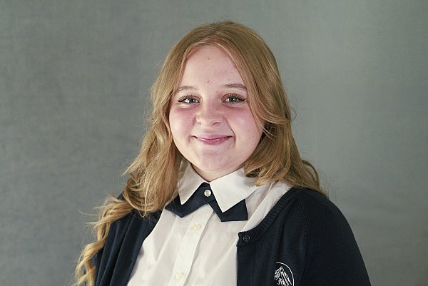 Blonde girl wearing school uniform on gray background for school picture day